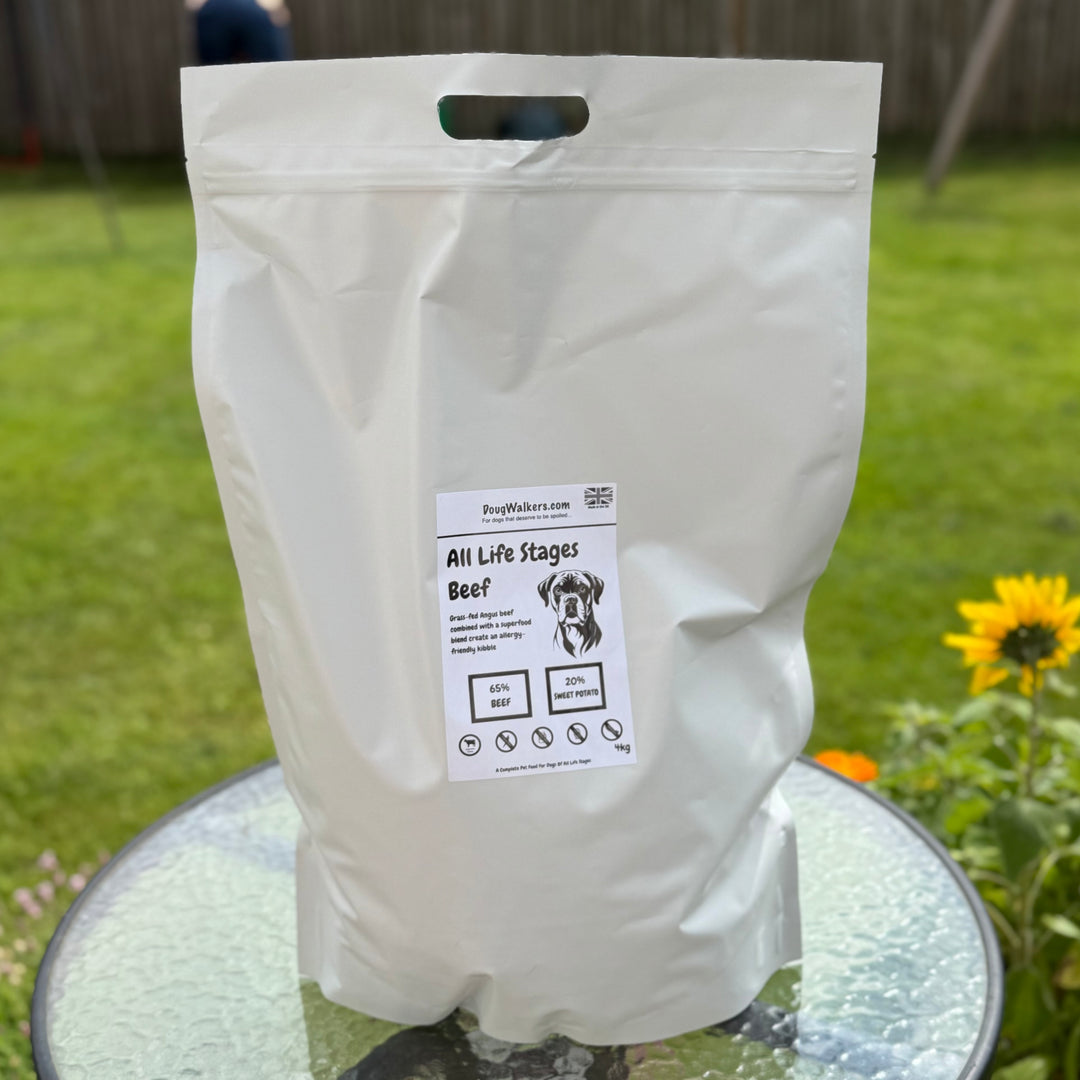 Doug Walkers All Life Stages Grain-Free Beef Dog Food 4kg bag on garden table with sunflowers in background